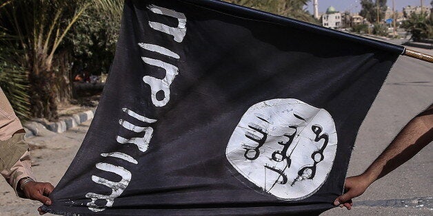 PALMYRIA, SYRIA. MARCH 26, 2016. Soldiers of Suqur al-Sahara (the Desert Falcons), branch of the Syrian Arab Army allied with the Syrian Government, show a seized flag of the so called Islamic State in Palmyra, a UNESCO world heritage site. On 27 March 2016 Palmyra was liberated from ISIS by the Syrian government army. Valery Sharifulin/TASS (Photo by Valery Sharifulin\TASS via Getty Images)