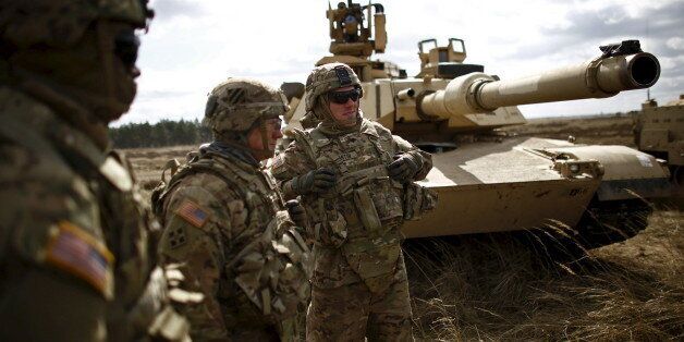Members of the U.S. 2nd Battalion, 7th Infantry Regiment, 1st Brigade Combat Team, 3rd Infantry Division stand in front of an Abrams tank during an exercises at Mielno range near Drawsko-Pomorskie April 16, 2015. REUTERS/Kacper Pempel