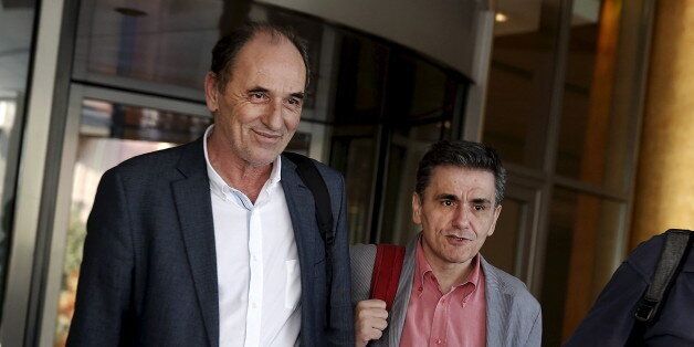 Greek Economy Minister George Stathakis (L) and Finance Minister Euclid Tsakalotos leave a hotel following an overnight meeting with representatives of the International Monetary Fund, the European Commission, the European Central Bank and the eurozone's rescue fund, the European Stability Mechanism in Athens, August 11, 2015. Greece and its international lenders clinched a multi-billion-euro bailout agreement on Tuesday after marathon talks through the night, officials said, raising hopes aid can be disbursed in time for a major debt repayment falling due in days. REUTERS/Alkis Konstantinidis