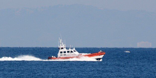 An Italian vessel from the European border agency Frontex assists the Greek Coast Guard in the search after a boat sinking near the eastern Greek island of Samos, as Turkey is seen in the background on Thursday, Jan. 28, 2016. Authorities in Greece have raised the death toll from a migrant boat sinking to 18, after recovering seven more bodies off the island of Samos in the eastern Aegean Sea. (AP Photo/Michael Svarnias)