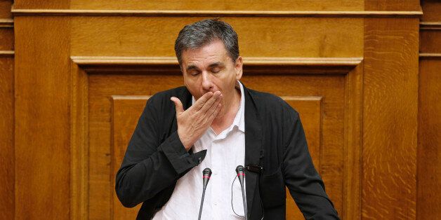 Greek Finance Minister Euclid Tsakalotos reacts as deputies attempt to disrupt his speech during a night parliamentary session in Athens, Greece, early August 14, 2015. Greek lawmakers debated a draft bill on the latest bailout deal, which the government hopes will be approved ahead of a euro zone finance ministers meeting in Brussels on Friday. REUTERS/Christian Hartmann TPX IMAGES OF THE DAY