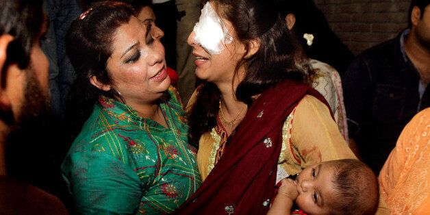 A woman injured in the bomb blast is comforted by a family member at a local hospital in Lahore, Pakistan, Sunday, March, 27, 2016. A bomb blast in a park in the eastern Pakistani city of Lahore has killed tens of people and wounded scores, a health official said. (AP Photo/K.M. Chuadary)