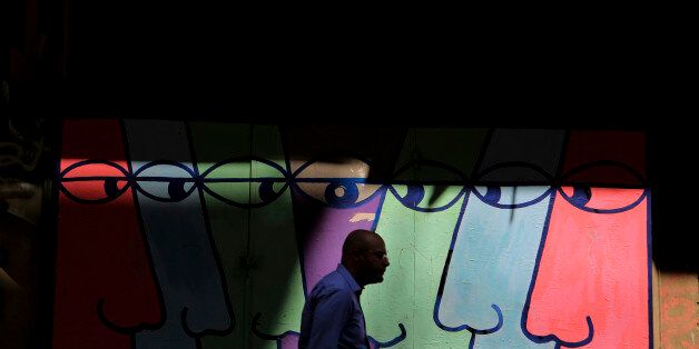 A pedestrian walks in front of a mural in central Athens, Monday, Aug. 26, 2013. In two bailout packages so far, Greece's European partners and the International Monetary Fund have committed euro 240 billion (US$320 billion) in loans. Last week, German Finance Minister Wolfgang Schaeuble said there will have to be another aid program after the current one expires next year. (AP Photo/Petros Giannakouris)