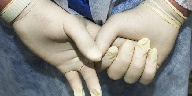 Hands wearing surgical gloves, close-up (Photo by Universal Images Group via Getty Images)