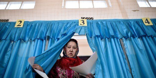 A woman votes during parliamentary elections in the Kazakh city of Baikonur, also known as Russian-leased Baikonur cosmodrom, about 1,400 km from Kazakh capital Astana on March 20, 2016. Citizens of energy-rich Kazakhstan went to the polls in an early parliamentary election expected to provide a commanding majority for ageing autocrat President Nursultan Nazarbayev's ruling Nur Otan party. / AFP / KIRILL KUDRYAVTSEV (Photo credit should read KIRILL KUDRYAVTSEV/AFP/Getty Images)