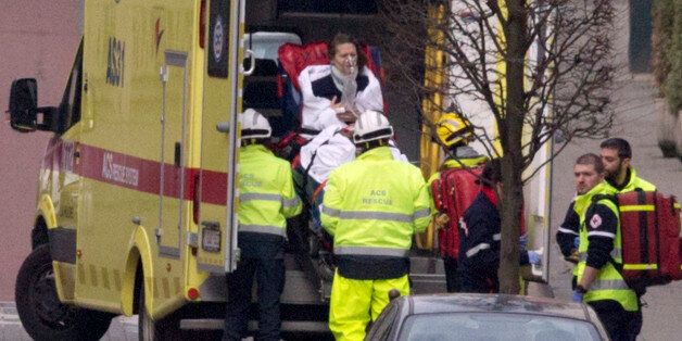 A woman is evacuated in an ambulance by emergency services after a explosion in a main metro station in Brussels on Tuesday, March 22, 2016. Explosions rocked the Brussels airport and the subway system Tuesday, killing at least 13 people and injuring many others just days after the main suspect in the November Paris attacks was arrested in the city, police said. (AP Photo/Virginia Mayo)