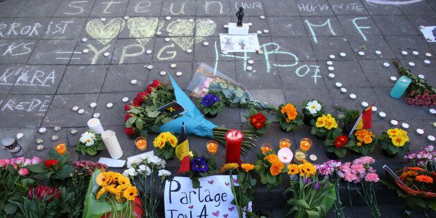 Floral tributes, candles and chalked messages of condolence sit on Beursplein square in Brussels, Belgium, on Tuesday, March 22, 2016. Explosions ripped through the Brussels airport departure hall and a downtown subway station on Tuesday morning, causing deaths and injuries and spurring fears of imminent follow-up attacks in the capital of the European Union. Photographer: Jasper Juinen/Bloomberg via Getty Images