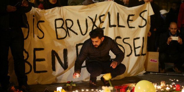 BRUSSELS, BELGIUM - MARCH 22: People hold up a banner as a mark of solidarity at the Place de la Bourse following today's attacks on March 22, 2016 in Brussels, Belgium. At least 31 people are thought to have been killed after Brussels airport and a Metro station were targeted by explosions. The attacks come just days after a key suspect in the Paris attacks, Salah Abdeslam, was captured in Brussels. (Photo by Carl Court/Getty Images)