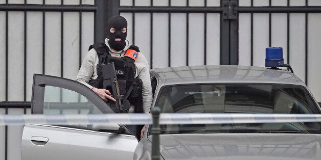 An armed special police officer expects suspect Salah Abdeslam to arrive at a justice building in Brussels, Belgium Thursday, March 24, 2016. Abdeslam, the chief suspect in last year's deadly Paris attacks, is facing a hearing in Brussels, amid increasing signs that the same Islamic State cell was behind attacks in both cities. (AP Photo/Martin Meissner)