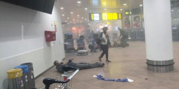 In this photo provided by Georgian Public Broadcaster and photographed by Ketevan Kardava a man is wounded in Brussels Airport in Brussels, Belgium, after explosions were heard Tuesday, March 22, 2016. A developing situation left a number dead in explosions that ripped through the departure hall at Brussels airport Tuesday, police said. All flights were canceled, arriving planes were being diverted and Belgium's terror alert level was raised to maximum, officials said. (Ketevan Kardava/ Georgian Public Broadcaster via AP)