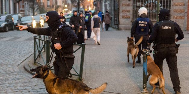 Police officers with dogs during a raid in the Molenbeek neighborhood of Brussels, Belgium, Friday March 18, 2016. After an intense four-month manhunt across Europe and beyond, police on Friday captured Salah Abdeslam, the top fugitive in the Paris attacks in the same Brussels neighborhood where he grew up. (AP Photo/Geert Vanden Wijngaert)