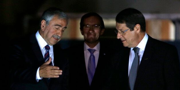 Cyprus' president Nicos Anastasiades, right, and Turkish Cypriot leader Mustafa Akinci shake hands as the United Nations envoy Espen Barth Eide, center, smiles before a dinner at the Ledra Palace Hotel inside the UN controlled buffer zone that divides the Cypriot capital Nicosia, on Monday, May 11, 2015. The dinner is the first meeting between Anastasiades and Akinci since the Turkish Cypriot politician _ a left-wing moderate _ soundly defeated the hard-line incumbent in an election last month. Cyprus was split in 1974 when Turkey invaded after a coup by supporters of union with Greece. (AP Photo/Petros Karadjias)