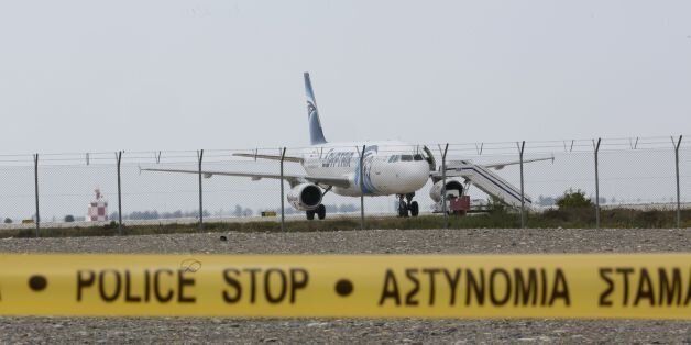 Cypriot security forces cordon off the area around Larnaca airport where an EgyptAir Airbus A-320 (C) is seen on the tarmac after being hijacked and diverted to Cyprus on March 29, 2016. / AFP / BEHROUZ MEHRI (Photo credit should read BEHROUZ MEHRI/AFP/Getty Images)