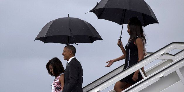 President Barack Obama, second from left, arrives with first lady Michelle Obama, left, and their daughters Sasha, front right, and Malia, as they exit Air Force One at the airport in Havana, Cuba, Sunday, March 20, 2016. Obama and his family are traveling to Cuba, the first U.S. president to visit the island in nearly 90 years. (Cubadebate/Ismael Francisco via AP)
