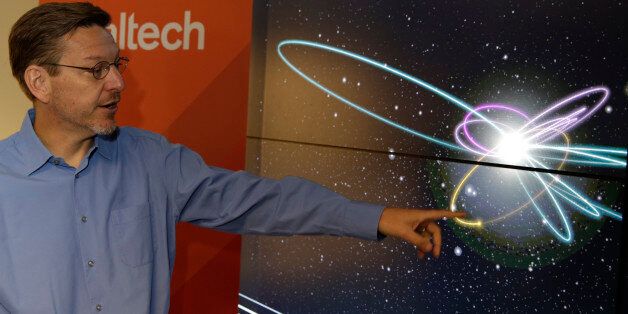 California Institute of Technology astronomer Michael Brown points to a yellow dot simulating Planet 9 on a computer video simulation view of Planet 9 in the solar system at the CalTech USGS Media center in Pasadena, Calif., on Wednesday, Jan. 20, 2016. Scientists reported Wednesday, they finally have