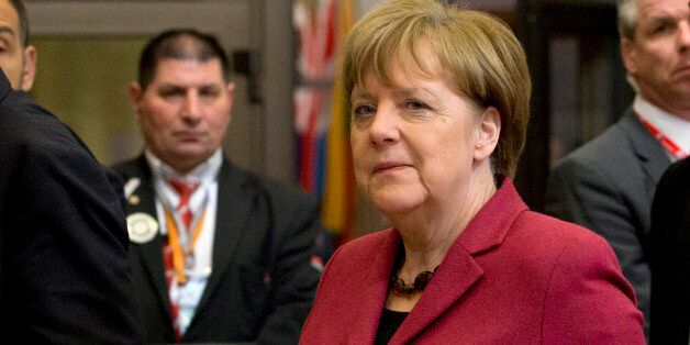 German Chancellor Angela Merkel, center, leaves an EU summit in Brussels on Friday, March 18, 2016. European Union leaders struggled to reach a deal Thursday that balanced their concerns about refugee law and Turkeyâs human rights record with their desperation to halt the migrant crisis. (AP Photo/Virginia Mayo)