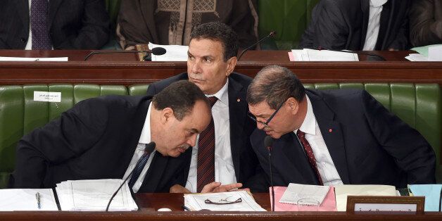 Tunisian Prime Minister Habib Essid (R) greets Interior Minister Mohamed Najem Gharsalli (L) and Defence Minister Farhat Horchani (C) before addressing the Tunisian parliament in Tunis on November 26, 2015 two days after the attack against presidential guards who were killed in a bomb blast on a bus in the centre of the Tunisian capital. Tunisia announced it is closing its land border with war-torn Libya for 15 days after a deadly bus bombing in Tunis claimed by the Islamic State group. AFP PHOTO / FETHI BELAID / AFP / FETHI BELAID (Photo credit should read FETHI BELAID/AFP/Getty Images)