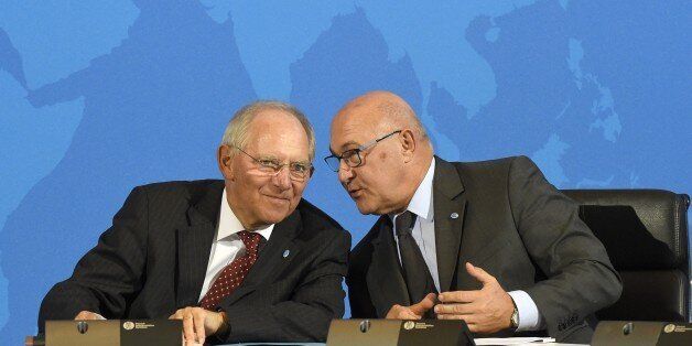 (LtoR) German Finance Minister Wolfgang Schaeuble and French Finance Minister Michel Sapin chat during a press conference after the signing of the Multilateral Competent Authority Agreement by more than 80 countries on October 29, 2014 in Berlin, as part of the Berlin Tax Conference. The agreement could put an end to banking secrecy in the global battle against tax evasion and fraud. AFP PHOTO / TOBIAS SCHWARZ (Photo credit should read TOBIAS SCHWARZ/AFP/Getty Images)