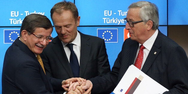 BRUSSELS, BELGIUM - MARCH 18: Turkey's Prime Minister, Ahmet Davutoglu (L) shakes hands with President of the European Council, Donald Tusk and President of the European Commission, Jean-Claude Juncker, after a press conference to discuss the migrant deal reached between Turkey and EU states, during a two-day EU summit, on March 18, 2016 in Brussels, Belgium. The EU has agreed a deal in which, from Sunday, all refugees and migrants arriving in Europe from Turkey will be returned to Turkey. (Photo by Carl Court/Getty Images)