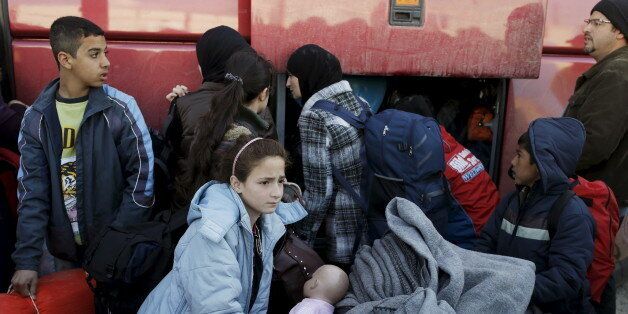 Migrants and refugees pack their belongings into a bus at a makeshift camp at the Greek-Macedonian border near the village of Idomeni, Greece, March 25, 2016. REUTERS/Marko Djurica