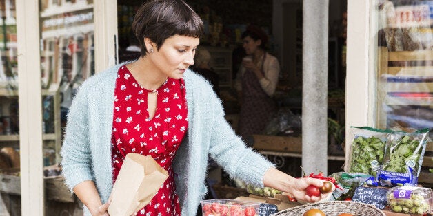 Woman selecting tomatoes at local farm shop.