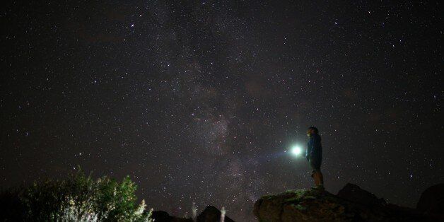A photographer prepares to take pictures of the annual Perseid meteor shower in the village of Crissolo,...