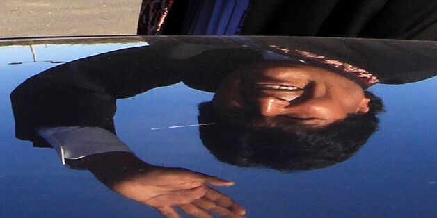 Bolivia's President Evo Morales is reflected on a car as he waves while leaving a charity event, in Lescar, near Pau, southwestern France, Saturday, Nov. 7, 2015. Morales is on a two day visit to France and will meet with French President Francois Hollande in Paris on Monday. (AP Photo/Bob Edme)