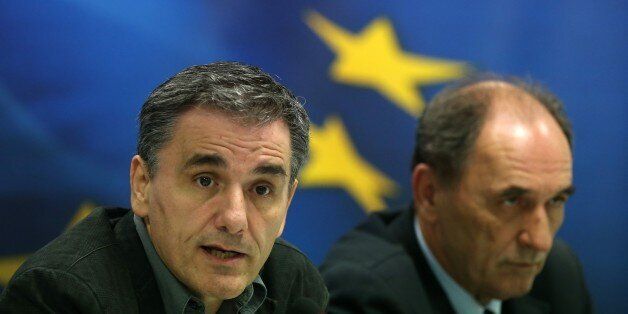 Greece's Finance Minister Euclid Tsakalotos, left, speaks during a news conference as Economy Minister Giorgos Sathakis listens, in Athens on Tuesday, Nov. 17, 2015. Greece reached an agreement with European creditors Tuesday on economic measures it needs to introduce so it can get its next batch of bailout money, including a 10 billion-euro ($10.7 billion) cash injection for its crippled banks. (AP Photo/Petros Giannakouris)
