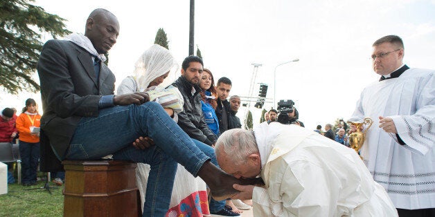 Pope Francis kisses the foot of a man during the foot-washing ritual at the Castelnuovo di Porto refugees center, some 30km (18, 6 miles) from Rome, Thursday, March 24, 2016. The pontiff washed and kissed the feet of Muslim, Orthodox, Hindu and Catholic refugees Thursday, declaring them children of the same God, in a gesture of welcome and brotherhood at a time when anti-Muslim and anti-immigrant sentiment has spiked following the Brussels attacks. (L'Osservatore Romano/Pool Photo via AP)