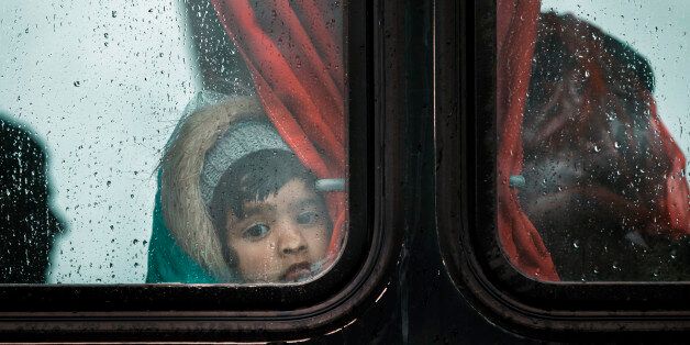 A migrant girl presses her nose agains a bus window during a rainfall on a road, north of Idomeni, Greece, Tuesday, March 15, 2016. Hundreds of migrants and refugees walked out Monday of an overcrowded camp on the Greek-Macedonian border Monday, determined to use a dangerous crossing to head north but were returned to Greece.(AP Photo/Vadim Ghirda)