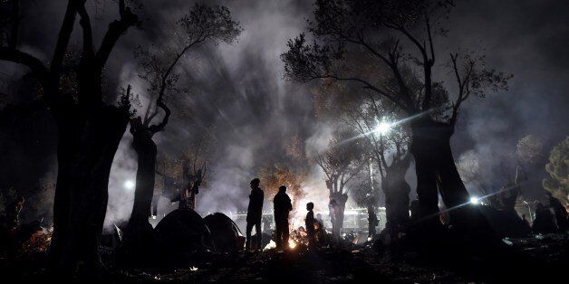 Refugees and migrants spend the night in a field outside of the Moria Hot Spot, on the Greek island of Lesbos on November 9, 2015. More than 3,000 refugees and migrants have drowned among the nearly 800,000 who have reached Europe this year. However, EU states have bickered for months over a joint solution, particularly over plans to relocate a total of 160,000 asylum seekers from frontline countries to other parts of the EU bloc. / AFP / ARIS MESSINIS (Photo credit should read ARIS MESSINIS/AFP/Getty Images)