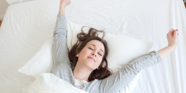 Young beautiful, woman waking up fully rested.