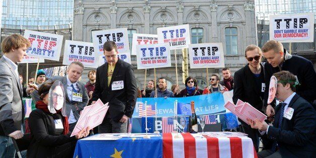 Activists demonstrate against the Transatlantic Trade and Investment Partnership (TTIP) between the EU and the USA outside the European Parliament at Luxembourg Place in Brussels on February 24, 2016.The TTIP, under negotiation since July 2013, would create the world's biggest free trade zone, removing tariffs and harmonising regulation between the European Union and the United States. Opponents say TTIP is undemocratic and would lead to reckless deregulation at the expense of ordinary citizens. / AFP / THIERRY CHARLIER (Photo credit should read THIERRY CHARLIER/AFP/Getty Images)