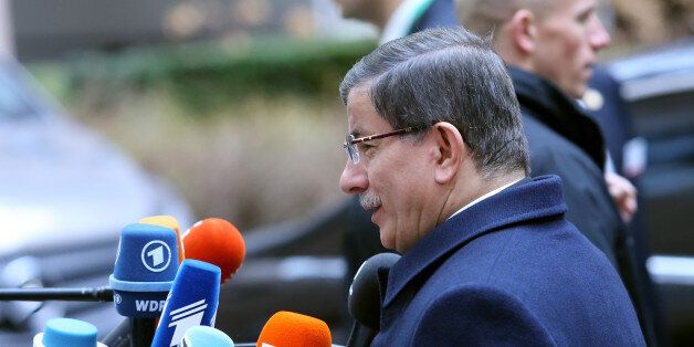Turkish Prime Minister Ahmet Davutoglu, center, speaks with the media as he arrives for an EU summit at the EU Council building in Brussels on Monday, March 7, 2016. European Union leaders are holding a summit in Brussels on Monday with Turkey to discuss the current migration crisis. (AP Photo/Francois Walschaerts)
