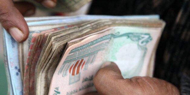 A vender counts bank notes at a market in Dhaka, Bangladesh, on Monday, Jan. 9, 2012. Bangladesh's central bank this month raised interest rates for the second time in four months to curb inflation that has exceeded 9 percent since the start of 2011. Photographer: Tomohiro Ohsumi/Bloomberg via Getty Images