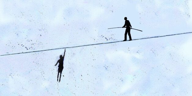 Businesswoman hanging from tightrope while businessman walks on top