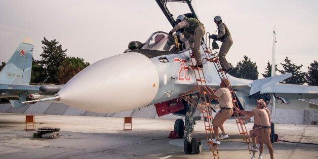 FILE - In this file photo taken on Thursday, Oct. 22, 2015, Russian air force pilots assisted by ground crew climb into their fighter jet at Hemeimeem airbase, Syria. (AP Photo/Vladimir Isachenkov, File)