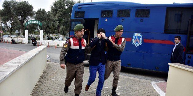 MUGLA, TURKEY - MARCH 2 : Turkish gendarmeries escort 2 Syrians, arrested on suspicion of causing deaths of 5 refugees including Aylan Kurdi,as they brought to the court in Mugla, Turkey on March 2, 2016. Aylan Kurdi,3 year old kid drowned after boat sank on route to the Greek islands in the Aegean Sea. (Photo by Ali Balli/Anadolu Agency/Getty Images)