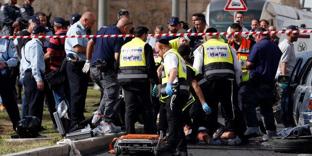 Israeli emergency personnel and security forces gather at the scene of an attack outside Jerusalem's Old City's New Gate on March 9, 2016. Two Palestinians opened fire at a bus in Jerusalem before fleeing and shooting again outside the Old City, leaving one person seriously wounded, Israeli police said. / AFP / AHMAD GHARABLI (Photo credit should read AHMAD GHARABLI/AFP/Getty Images)