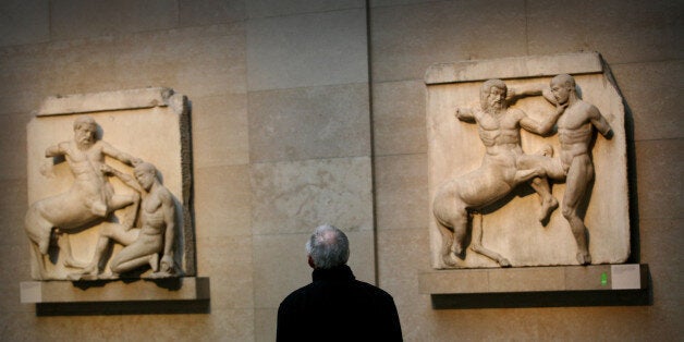 UNITED KINGDOM - FEBRUARY 06: A visitor studies part of the Elgin Marbles collection at the British Museum in London, Monday, February 6, 2006. For more than 20 years, Greek officials have demanded that the British Museum return sculptures taken from the Parthenon, a request repeatedly turned down by successive U.K. governments. That hasn't stopped Athens from building a 130 million euro ($155 million) facility to house the disputed treasures. (Photo by Graham Barclay/Bloomberg via Getty Images)