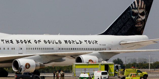 Local police stand beside the aircraft of English heavy metal band Iron Maiden, after it was damaged while on the ground when a steering pin evidently fell out, at the airport in Santiago, Chile, Saturday, March 12, 2016. Iron Maiden's statement said the plane suffered a collision when it made a turn, injuring two workers on the ground. They were taken to a hospital for treatment. (Marcelo Hernandez/Aton Chile via AP) CHILE OUT - NO USAR EN CHILE