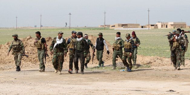 Iraqi Shiite fighters from the Popular Mobilisation units gather on a road in the desert of Samarra, on March 3, 2016, during an operation aimed at retaking areas from the Islamic State (IS) jihadist group.Counter-terrorism forces, soldiers, police and allied paramilitaries are taking part in an operation launched on March 1, which is backed by artillery and both Iraqi and US-led coalition aircraft, aimed at retaking areas north of Baghdad, according to the Joint Operations Command. An Iraqi army colonel said that more than 7,000 security personnel would take part in the operation, which the operations command said aims to retake areas west of the city of Samarra. / AFP / AHMAD AL-RUBAYE (Photo credit should read AHMAD AL-RUBAYE/AFP/Getty Images)