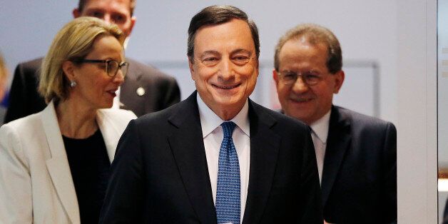 President of European Central Bank Mario Draghi is on his way to a press conference following a meeting of the governing council in Frankfurt, Germany, Thursday, March 10, 2016. The European Central Bank cut all its main interest rates, expanded its bond-buying stimulus program, and offered new cheap loans to banks, making an unexpectedly aggressive effort to boost inflation and economic growth in the 19 countries that share the euro. (AP Photo/Michael Probst)