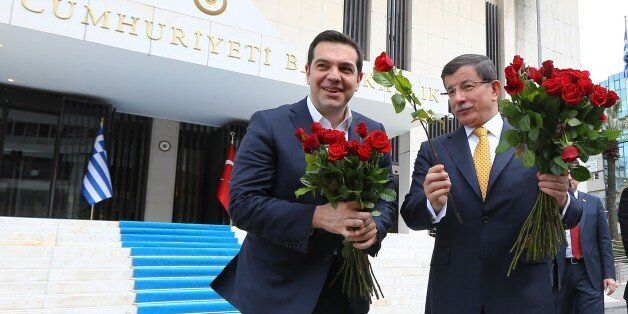 IZMIR,TURKEY - MARCH 08: Turkish Prime Minister Ahmet Davutoglu (right) welcomes Greek Prime Minister Alexis Tsipras (left) give red roses to the female journalists to mark International Women's Day prior to their meeting at the Prime Ministry Office in Izmir, Turkey on March 08, 2016. (Photo by Hakan Goktepe/Anadolu Agency/Getty Images)