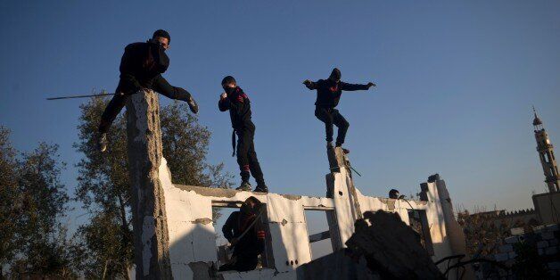 Palestinian youth, members of a Gazan martial art group, perform their ninja-like skills at ruins of a house, that was destroyed in the 2014 war between Israel and Hamas militants, in Beit Hanoun in the northern Gaza Strip, on February 11, 2016. / AFP / MOHAMMED ABED (Photo credit should read MOHAMMED ABED/AFP/Getty Images)