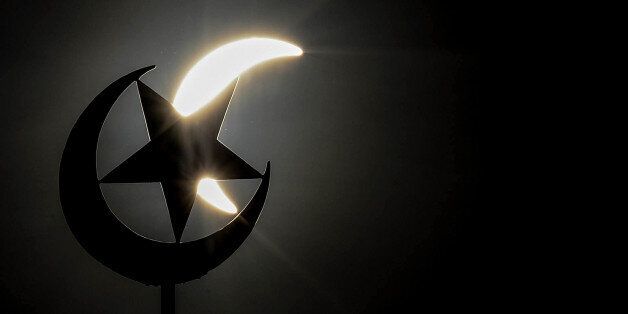 A general view shows a partial solar eclipse behind a star and crescent symbol atop a mosque in Kuala Lumpur on March 9, 2016.A total solar eclipse swept across the vast Indonesian archipelago on March 9, witnessed by tens of thousands of sky gazers and marked by parties, Muslim prayers and tribal rituals. Partial eclipses were also visible over other parts of Asia and Australia. / AFP / MANAN VATSYAYANA (Photo credit should read MANAN VATSYAYANA/AFP/Getty Images)