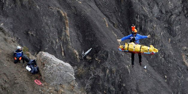 FOR USE AS DESIRED, YEAR END PHOTOS - FILE - A rescue worker is lifted into an helicopter at the crash site near Seyne-les-Alpes, France, Thursday, March 26, 2015. The co-pilot of a Germanwings jet barricaded himself in the cockpit and rammed the plane full speed into the French Alps, ignoring the captain's frantic pounding on the cockpit door and the screams of terror from passengers. In a split second, he killed all 150 people aboard the plane. (AP Photo/Laurent Cipriani, File)