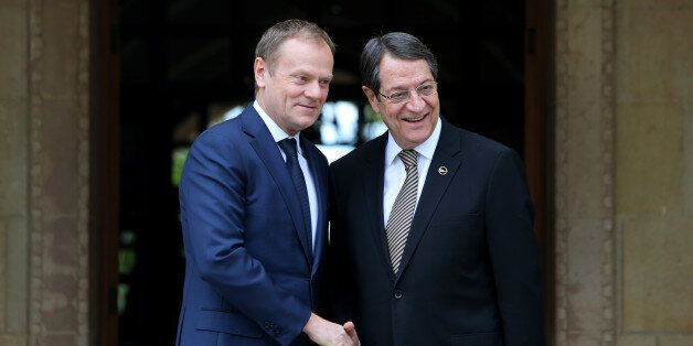 European Council President Donald Tusk, left, shakes hands with Cyprus President Nicos Anastasiades at the Presidential Palace before their meeting in the ethnically divided island's capital Nicosia on Tuesday, March 15, 2016. Tusk is in Cyprus to sound out the Cypriot president on unblocking Turkey's EU accession negotiations in order to clinch a sought-after deal with Ankara on stemming the flow of migrants into the continent. (AP Photo/Petros Karadjias)