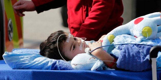 5-year-old Ashya King is loaded into an ambulance after first proton beam treatment of his brain tumor at Proton Therapy Center in Prague, Czech Republic, Monday, Sept. 15, 2014. Ashyaâs parents have fought a protracted battle to get their son treated with proton beam technology, which targets tumors more directly than radiotherapy but is not yet available for patients with brain tumors in Britain. (AP Photo/Petr David Josek)