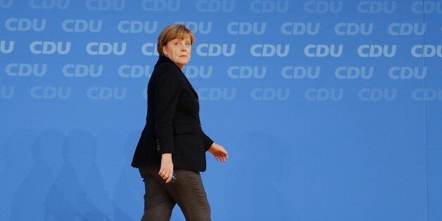 German Chancellor Angela Merkel walks away during a party convention of the Christian Democrats (CDU) in Karlsruhe, Germany, Monday, Dec. 14, 2015. Germany will reduce the influx of migrants coming in, Merkel promised her conservative party on Monday, insisting that she's still confident her approach will work and Europe will pass its